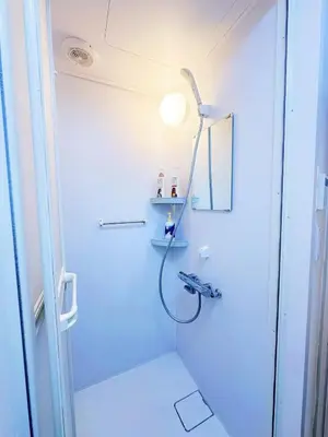 a white bathroom with a shower and a light at \u6587\u4eachouse103 in Tokyo