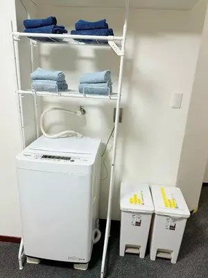 a laundry room with a washer and dryer on a shelf at \u6587\u4eachouse103 in Tokyo