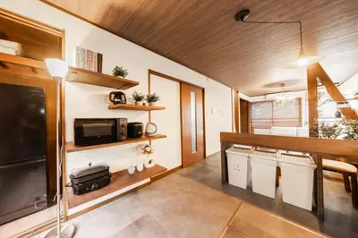 a living room with a television and a kitchen at 8 min walk to station 11 min to HND airport 85 sqm max 8 people full renovation 2 toilets Netflix in Tokyo