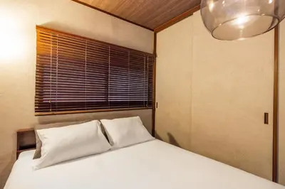 a bed with white pillows in a room with a window at 8 min walk to station 11 min to HND airport 85 sqm max 8 people full renovation 2 toilets Netflix in Tokyo