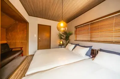 a bedroom with a large bed and a couch at 8 min walk to station 11 min to HND airport 85 sqm max 8 people full renovation 2 toilets Netflix in Tokyo