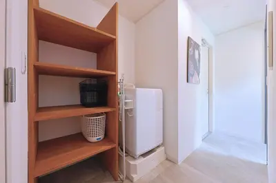 a kitchen with a refrigerator in a room at Oneness House Tokyo \u6771\u4eac\u56db\u30c4\u6728 in Tokyo