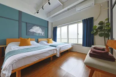 a bedroom with two beds and a large window at Oneness House Tokyo \u6771\u4eac\u56db\u30c4\u6728 in Tokyo