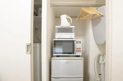 a microwave on top of a refrigerator in a kitchen at Kabukicho 507-SJ0011 in Tokyo