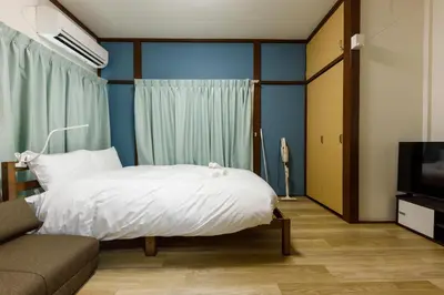 a bedroom with a bed and a couch and a television at M-Stay Nishishinjuku II, Room 202 in Tokyo