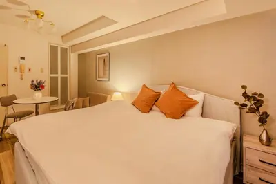 a bedroom with a large white bed with orange pillows at Feel Stay\u9053\u7384\u5742506 in Tokyo