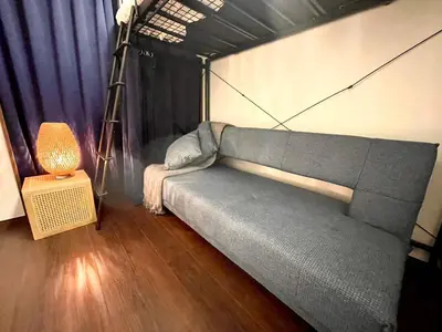 a living room with a couch and a lamp at n'imo HOUSE 101 in Tokyo