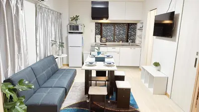 a living room with a blue couch and a kitchen at Uenoyuyunoie - Vacation STAY 19367 in Tokyo