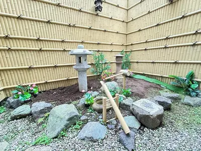 a garden with a fountain and a birdbath in front of a fence at GreatViewHouse - Vacation STAY 19425 in Tokyo