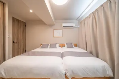 two beds in a small room with curtains at Improve Nishi Magome - Vacation STAY 19541 in Tokyo