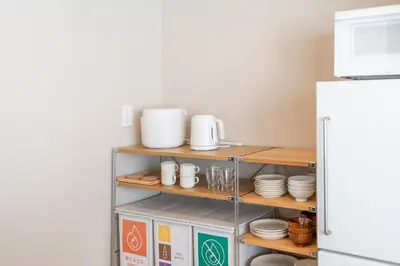 a kitchen with a shelf with dishes and a refrigerator at Improve Nishi Magome - Vacation STAY 19541 in Tokyo
