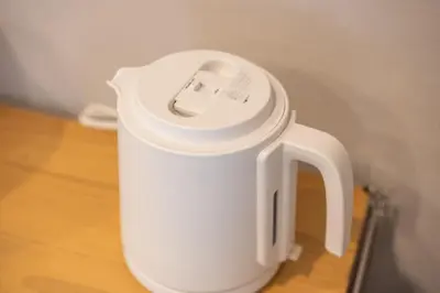 a white electric kettle sitting on a wooden table at Improve Nishi Magome - Vacation STAY 19541 in Tokyo