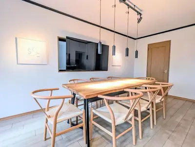 a dining room with a wooden table and chairs at \u30e1\u30fc\u30a4\u30f3\u65b0\u5bbf in Tokyo