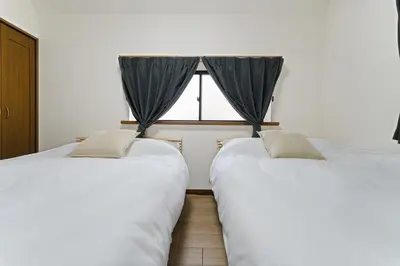 two beds in a room with a window at \u30e1\u30fc\u30a4\u30f3\u65b0\u5bbf in Tokyo