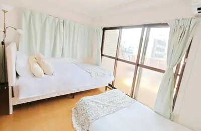 two beds in a room with a window at SkyTree-501 in Tokyo