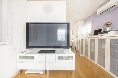 a large flat screen tv sitting on top of a white cabinet at Yoyogi Detached house Y4BD in Tokyo