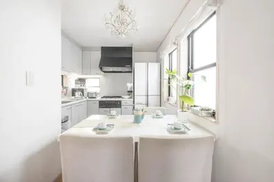 a white kitchen with white cabinets and a white island at Yoyogi Detached house Y4BD in Tokyo