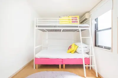 a room with a bunk bed with a pink bench at Yoyogi Detached house Y4BD in Tokyo
