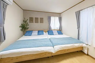 a bedroom with a large bed with blue pillows at Bnn\u5800\u52072\u4e01\u76eeESTA III in Tokyo