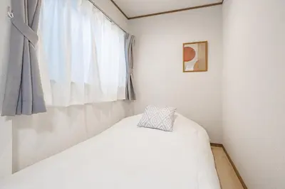 a white bedroom with a bed and a window at Bnn\u5800\u52072\u4e01\u76eeESTA III in Tokyo