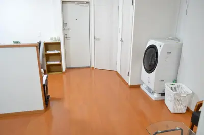 a room with a wooden floor and a washing machine at \u677e\u8f1d\u65c5\u9928 in Tokyo