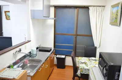 a kitchen with a sink and a table and a counter top at \u677e\u8f1d\u65c5\u9928 in Tokyo