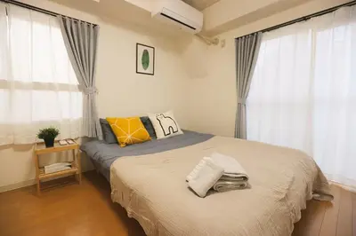 a bedroom with a bed and two windows at Jr\u5c71\u624b\u7ebf\u5927\u585a\u7ad9\u6b65\u884c1\u5206\u949f\u5730\u5904\u5546\u5e97\u8857\u7684\u65e0\u654c\u4fbf\u5229 in Tokyo