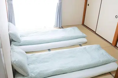 three empty beds in a room with a window at Jr\u5c71\u624b\u7ebf\u5927\u585a\u7ad9\u6b65\u884c1\u5206\u949f\u5730\u5904\u5546\u5e97\u8857\u7684\u65e0\u654c\u4fbf\u5229 in Tokyo