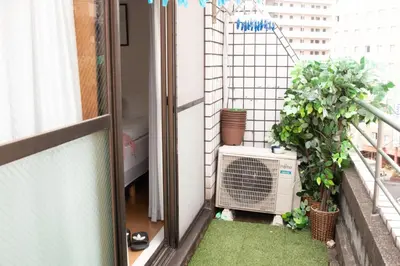 an apartment balcony with an air conditioner and plants at Jr\u5c71\u624b\u7ebf\u5927\u585a\u7ad9\u6b65\u884c1\u5206\u949f\u5730\u5904\u5546\u5e97\u8857\u7684\u65e0\u654c\u4fbf\u5229 in Tokyo