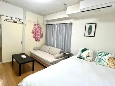 a bedroom with a white bed and a couch at Jr\u5c71\u624b\u7ebf\u5927\u585a\u7ad9\u6b65\u884c1\u5206\u949f\u5730\u5904\u5546\u5e97\u8857\u7684\u65e0\u654c\u4fbf\u5229 in Tokyo