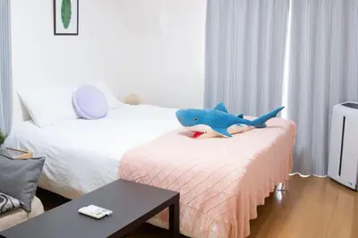 a stuffed shark sitting on a bed in a room at Jr\u5c71\u624b\u7ebf\u5927\u585a\u7ad9\u6b65\u884c1\u5206\u949f\u5730\u5904\u5546\u5e97\u8857\u7684\u65e0\u654c\u4fbf\u5229 in Tokyo