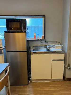 a kitchen with a stainless steel refrigerator and a sink at Takashi Vada Home in Tokyo
