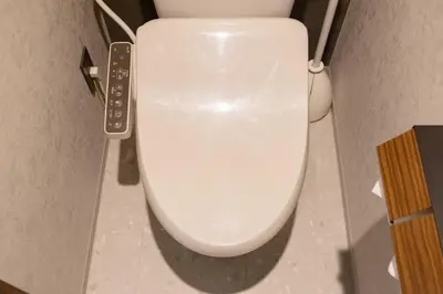 a white toilet in a bathroom with a remote control at Hotel Numero dix in Tokyo