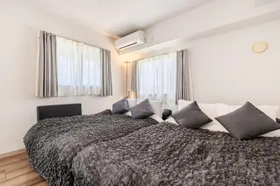 a bedroom with a large bed with gray and white pillows at Matcha Inn Sakura Tokyo 2 in Tokyo