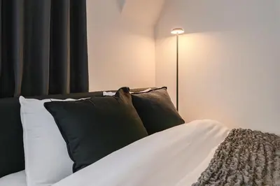 a bed with black and white pillows and a lamp at Matcha Inn Sakura Tokyo 2 in Tokyo