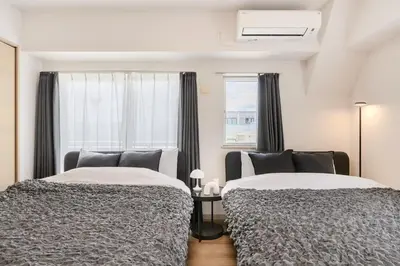 a bedroom with two beds and a window at Matcha Inn Sakura Tokyo 2 in Tokyo