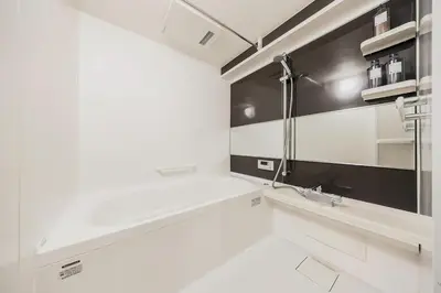 a white bathroom with black and white walls and a sink at Matcha Inn Sakura Tokyo 2 in Tokyo