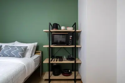 a bedroom with a bed and a tv on a shelf at CraftFlat Komagome 602, a compact studio at excellent location in Tokyo