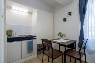 a small kitchen with a table and chairs and a sink at CraftFlat Komagome 602, a compact studio at excellent location in Tokyo