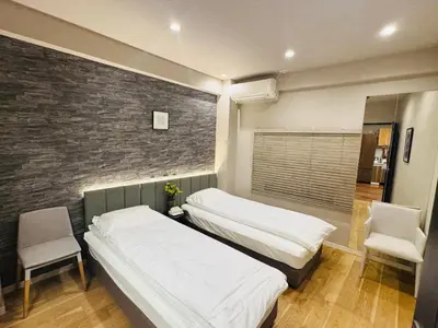 a bedroom with two beds and a brick wall at AhaiHotel in Wada