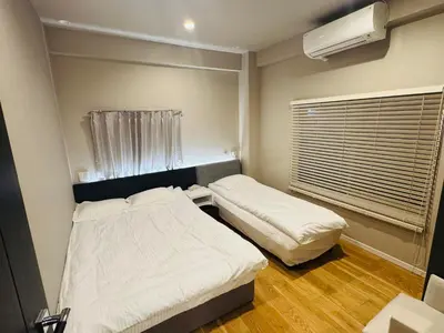 two beds in a small room with a window at AhaiHotel in Wada