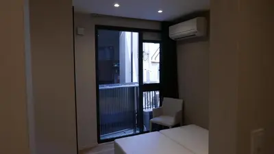 a room with a bed and a window with a balcony at AhaiHotel in Wada