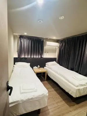 a bedroom with two beds and a table in it at AhaiHotel in Wada