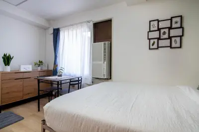a white bedroom with a bed and a table at CraftFlat Komagome 601, a compact studio at excellent location in Tokyo