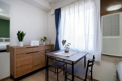 a bedroom with a table and a bed and a window at CraftFlat Komagome 601, a compact studio at excellent location in Tokyo