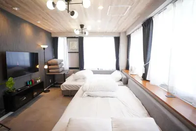 a living room with two beds and a flat screen tv at Hotel iemirai Araiyakushi - Shinjuku 9min train ride in Tokyo