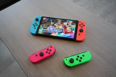 three different colored video game controllers sitting on a table at Hotel iemirai Araiyakushi - Shinjuku 9min train ride in Tokyo