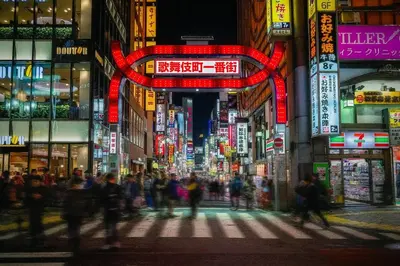 a crowd of people crossing a busy city street at night at Hotel iemirai Araiyakushi - Shinjuku 9min train ride in Tokyo