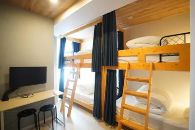 a bedroom with bunk beds with a desk and a television at Hotel iemirai Araiyakushi - Shinjuku 9min train ride in Tokyo