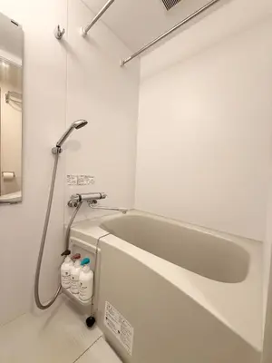 a bathroom with a bath tub with water bottles at Shibuya Simplex 3F, sunlight and 2 beds in Tokyo
